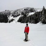 A snowshoer admire frozen Mowich Lake 2