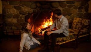 Couple sitting next to the National Park Inn fireplace. Image for Rustic Romance Adventure